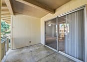 Thumbnail 30 of 33 - A room with a sliding glass door and a concrete floor.
