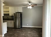 Thumbnail 20 of 43 - A kitchen with a refrigerator, cabinets, and a ceiling fan.