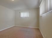 Thumbnail 23 of 37 - A room with a carpeted floor and a window with blinds.
