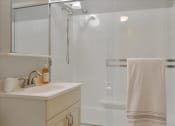 Thumbnail 27 of 35 - A white towel hangs on a glass shower door.