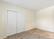 Thumbnail 29 of 43 - A room with a white door and carpeted floor.