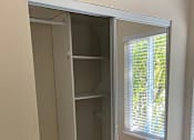 Thumbnail 34 of 43 - A white closet with a mirrored door is open.