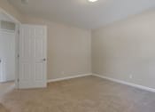 Thumbnail 30 of 34 - A room with a white door and carpeted floor.