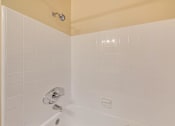 Thumbnail 29 of 29 - A white bathtub with a shower head and faucet.
