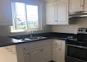 Thumbnail 24 of 26 - a kitchen with white cabinets and a sink and a window