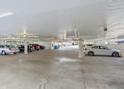 Thumbnail 71 of 92 - A parking garage with several cars parked inside.