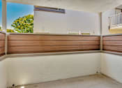 Thumbnail 24 of 41 - A balcony with a white wall and brown wooden slats.