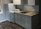 Thumbnail 14 of 31 - A kitchen with a white refrigerator, a white stove, and white cabinets.