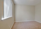 Thumbnail 29 of 34 - A room with a window and carpeted floor.