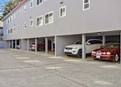 Thumbnail 2 of 29 - a parking lot with cars parked in front of a building