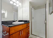 Thumbnail 10 of 37 - A bathroom with a sink, mirror, and shower.