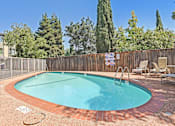 Thumbnail 4 of 27 - A  pool surrounded by a wooden fence and trees.