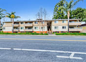Thumbnail 37 of 62 - A multi-story apartment building with a parking lot in front.