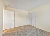 Thumbnail 35 of 43 - A room with two doors and a carpeted floor.