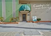 Thumbnail 3 of 16 - The front of the Country Club Apartments building with a green awning.