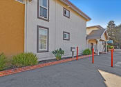 Thumbnail 4 of 35 - A building with a red brick border around a parking lot.