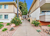 Thumbnail 36 of 62 - A row of houses with a sidewalk in between.