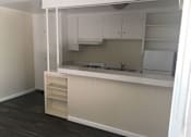 Thumbnail 22 of 31 - A kitchen with white cabinets and a countertop.