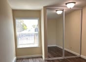 Thumbnail 16 of 36 - an empty living room with a large window and wooden floors