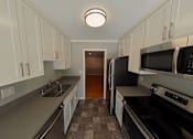 Thumbnail 38 of 47 - A kitchen with black appliances and white cabinets.