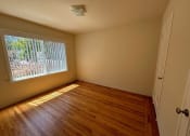 Thumbnail 6 of 19 - an empty room with a large window and wooden floors