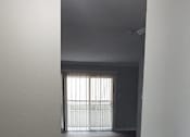 Thumbnail 28 of 30 - A room with wooden flooring and a window with blinds.