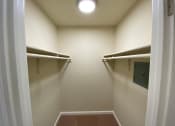 Thumbnail 40 of 51 - a walk in closet with white walls and a ceiling light
