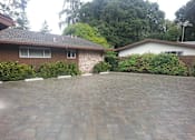 Thumbnail 17 of 38 - A driveway with a brick wall and two houses.