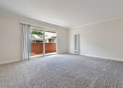 Thumbnail 34 of 52 - A room with a carpeted floor and a sliding glass door leading to a balcony.