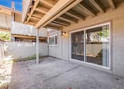 Thumbnail 31 of 40 - A patio area with a sliding glass door and a concrete floor.