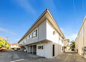 Thumbnail 26 of 42 - A white building with a triangular roof and a clear blue sky above.
