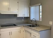 Thumbnail 13 of 22 - A kitchen with white cabinets and a granite countertop.