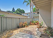 Thumbnail 12 of 37 - A backyard with a wooden fence and a small garden.