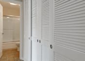 Thumbnail 31 of 33 - a white closet with white shuttered doors in a bathroom