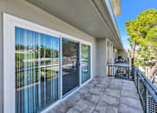 Thumbnail 13 of 92 - A balcony with a glass door leading to a patio.