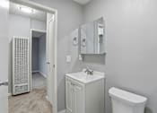 Thumbnail 16 of 55 - A white bathroom with a toilet, sink, and mirror.