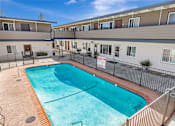 Thumbnail 25 of 44 - A swimming pool in a residential area surrounded by a fence.