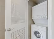 Thumbnail 8 of 37 - A white washing machine is in a small white closet.