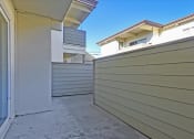Thumbnail 30 of 35 - A view of a building with a grey wall and a white door.