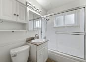 Thumbnail 52 of 63 - A white bathroom with a toilet, sink, and shower.