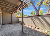 Thumbnail 26 of 40 - A patio area with a concrete floor and a wall with a sliding door.