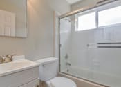 Thumbnail 34 of 34 - A white bathroom with a toilet, sink, and shower.