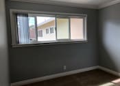 Thumbnail 26 of 43 - A room with a window and a carpeted floor.