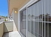 Thumbnail 6 of 37 - A balcony with a glass door and a concrete floor.
