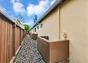 Thumbnail 10 of 38 - A long, narrow building with a brown fence on the left side.