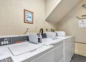 Thumbnail 16 of 43 - A row of white washing machines in a laundromat.
