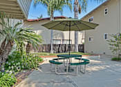 Thumbnail 14 of 37 - A patio with a green table and a green umbrella.