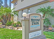 Thumbnail 2 of 37 - A sign for Middle Park Apartments stands in front of a building.