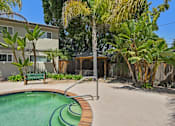 Thumbnail 3 of 37 - A pool surrounded by a concrete patio and a wooden deck.
