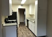 Thumbnail 23 of 43 - A kitchen with white cabinets and a black fridge.
